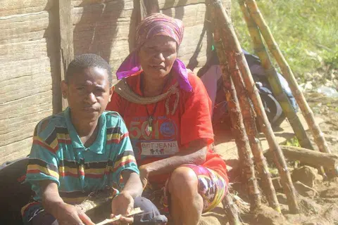 wanda:wekima: maketena: weliako tapasa:ma:mee. /  A lad and his mother with a harvested sugarcanes.
